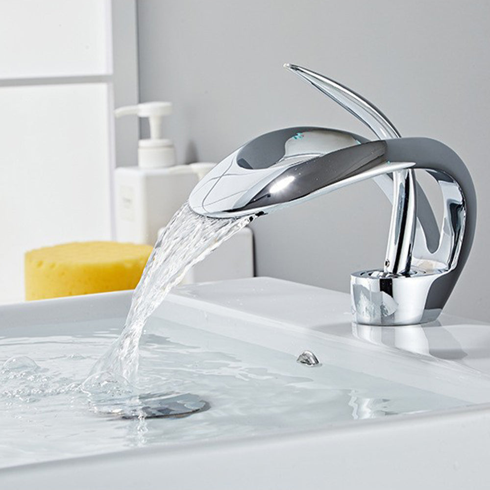 Chrome brass waterfall basin mixer tap with water flowing from the broad outlet