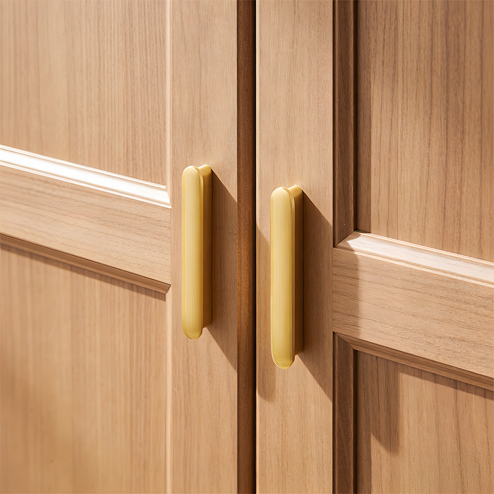 Gold brass T-bar handles fitted to wooden cabinet doors