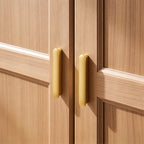 Gold brass T-bar handles fitted to wooden cabinet doors